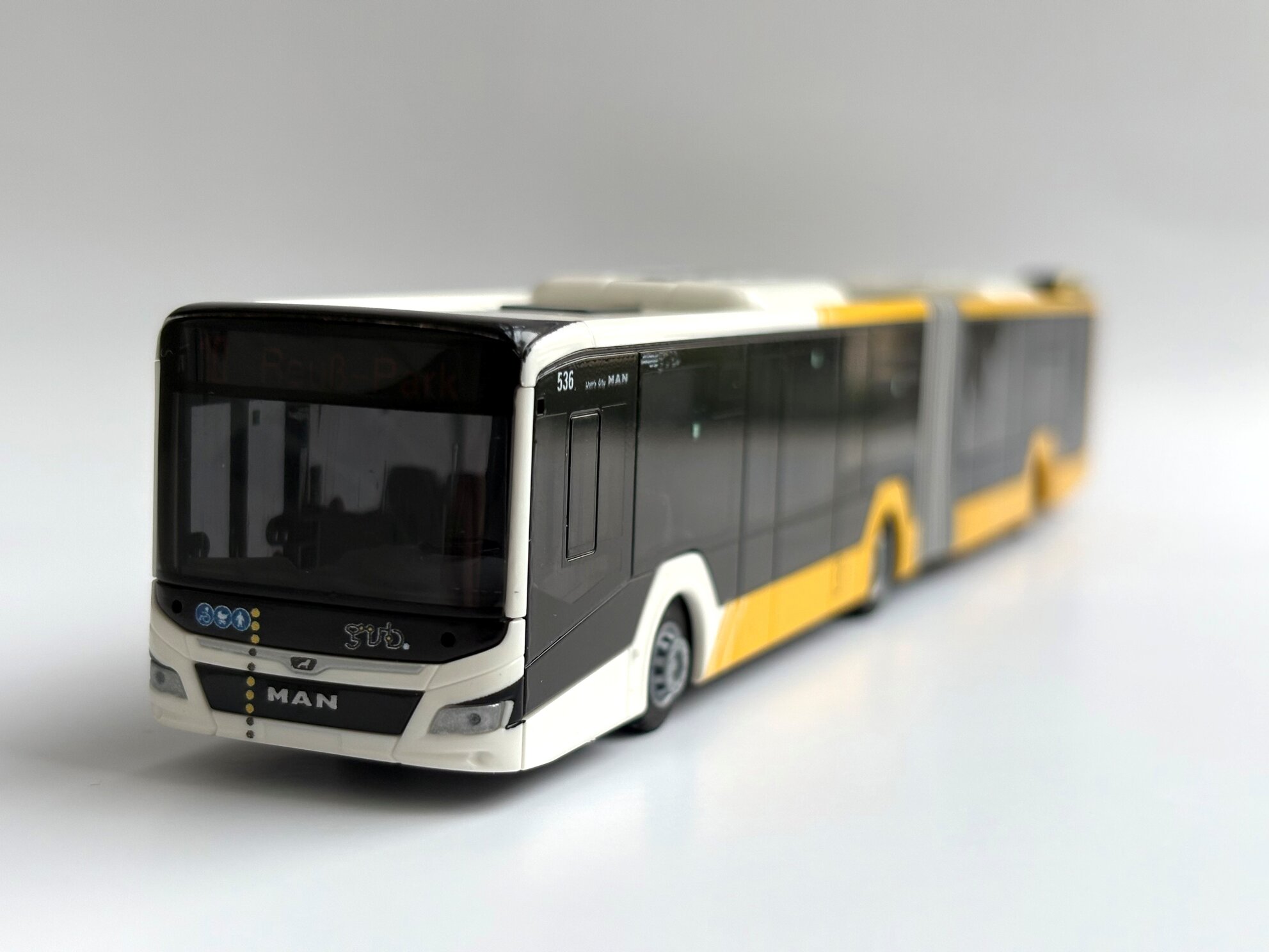 Modell des GVB-Gelenkbusses MAN Lion’s City 18 im Maßstab 1:87, im aktuellen GVB-Design, auf hellem Hintergrund.